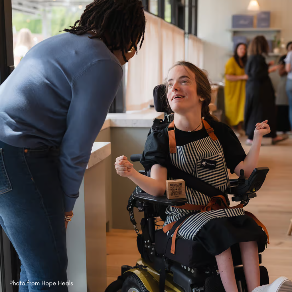 hoto of a Mend Coffee employee using a wheelchair talking to a customer