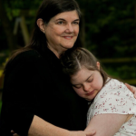 screenshot of Washington Post essay "A mystery illness stole their kids' personalities. These moms fought for answers" and photo of a mother and a daughter, who has Down syndrome, giving each other a hug
