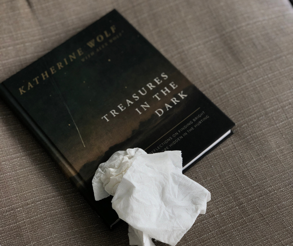 wadded up tissues on top of the Treasures in the Darkness book