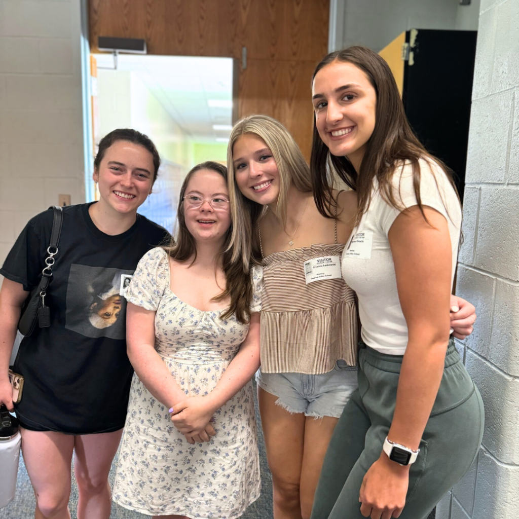 Penny poses with three friends who are in college who came to watch her presentation.