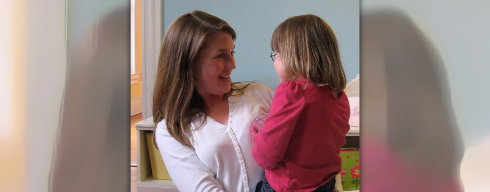 photo of Amy Julia holding toddler Penny. They are looking at each other and smiling