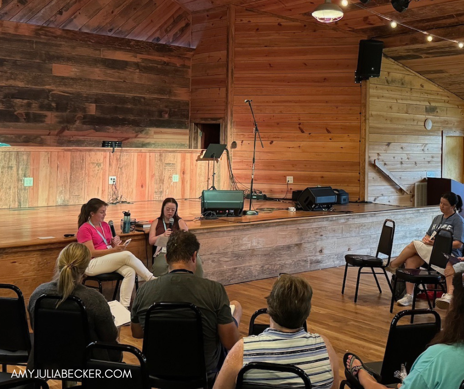 Amy Julia and Penny sit in a chapel and are surrounded by other people sitting and listening to them