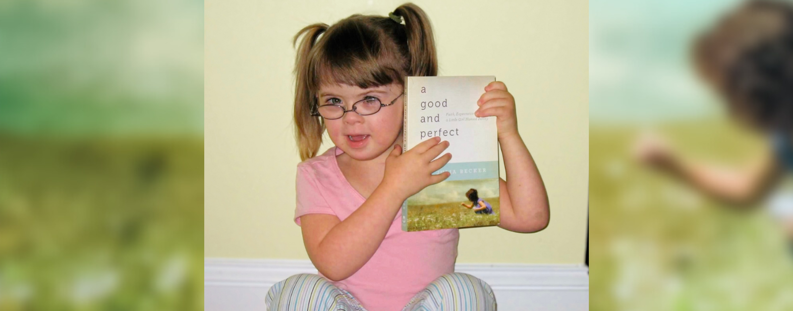 2011 photo of Penny holding a copy of GPG. She is wearing pigtails and smiling as she looks over her glasses