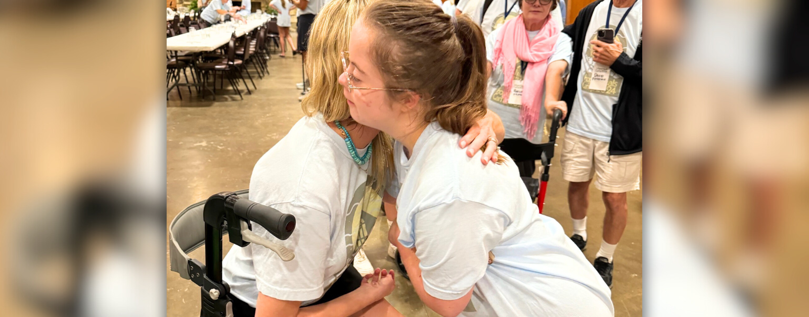 Katherine Wolf and Penny give each other a hug. They are both wearing Hope Heals Camp t-shirts