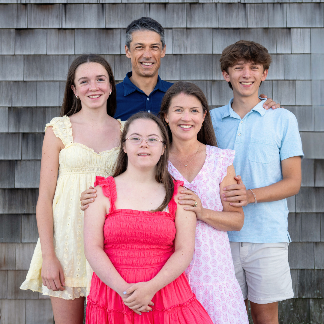 Amy Julia's family poses in front of a weathered building