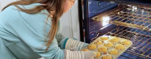 Penny getting muffins out of the oven