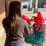 Penny pushes a shopping cart full of Target bags toward the parking lot