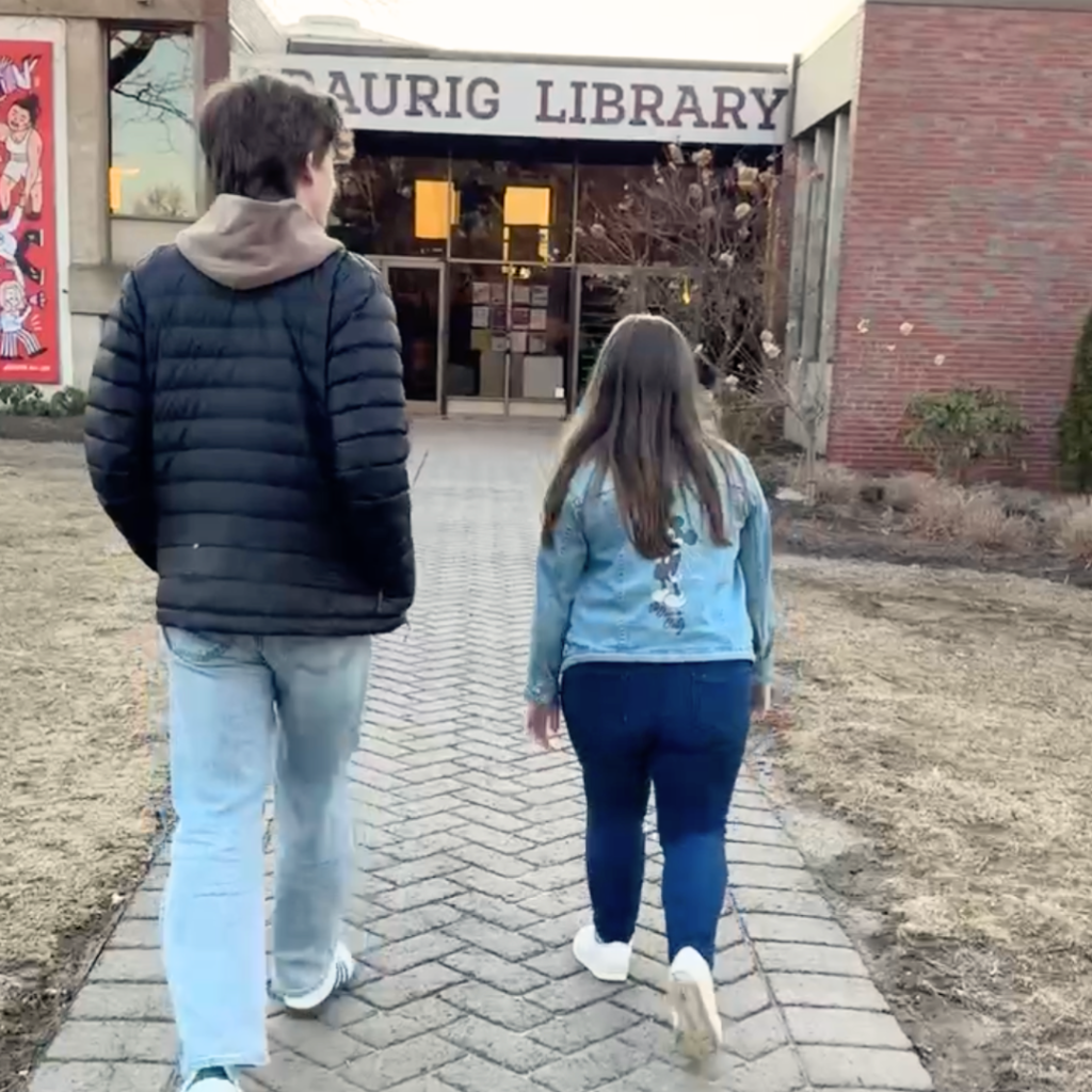 William and Penny walk toward the entrance of Traurig Library.