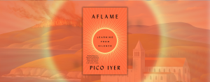 The image shows the cover of a book titled "Aflame: Learning from Silence" by Pico Iyer. The cover has an orange and red color scheme with a radiating circular design in the center. The background behind the book cover is a scenic landscape featuring rolling hills, a body of water, a burning forest, and a monastery or church building, all enveloped in warm orange tones, symbolizing the theme of fire or intensity suggested by the title.