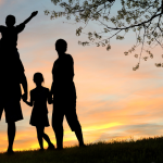 family silhouette against a sunset