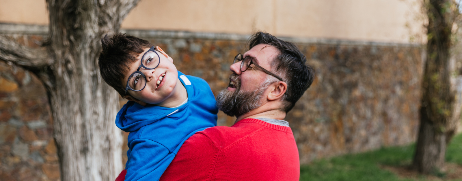 photo of a dad smiling at his disabled son