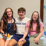 Marilee, William, and Penny sit on a bed in the dorm room at boarding school.