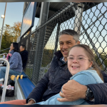 Peter and Penny sit on bleachers together