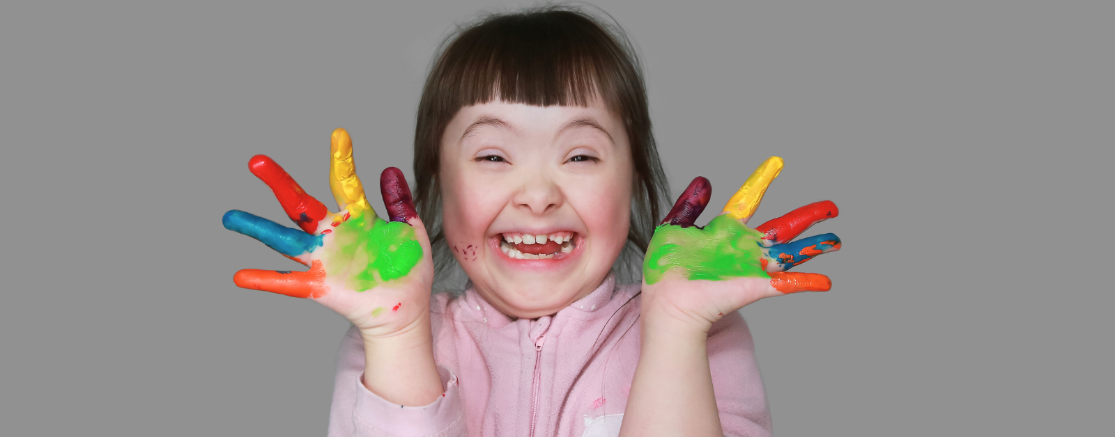 Grinning Little Girl with Down Syndrome with Painted Hands