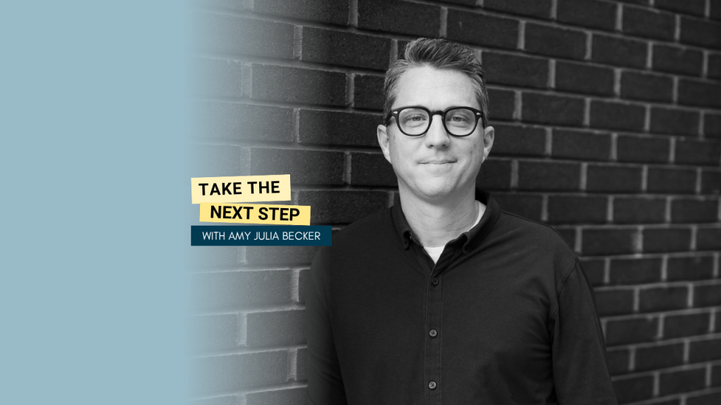 Matt Mooney poses for a black and white portrait against a brick wall. Bold text in yellow text boxes near the middle of the photo says Take the Next Step.