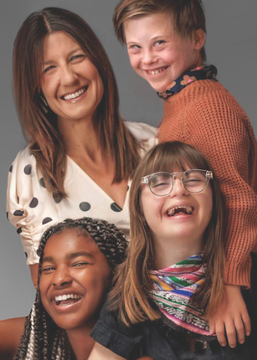 Disability advocate Heather Avis and her kids, two of whom have Down syndrome, pose for a portrait. They are all widely smiling