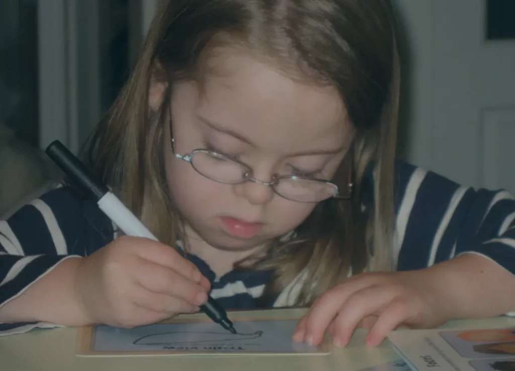 Penny sits at a desk tracing