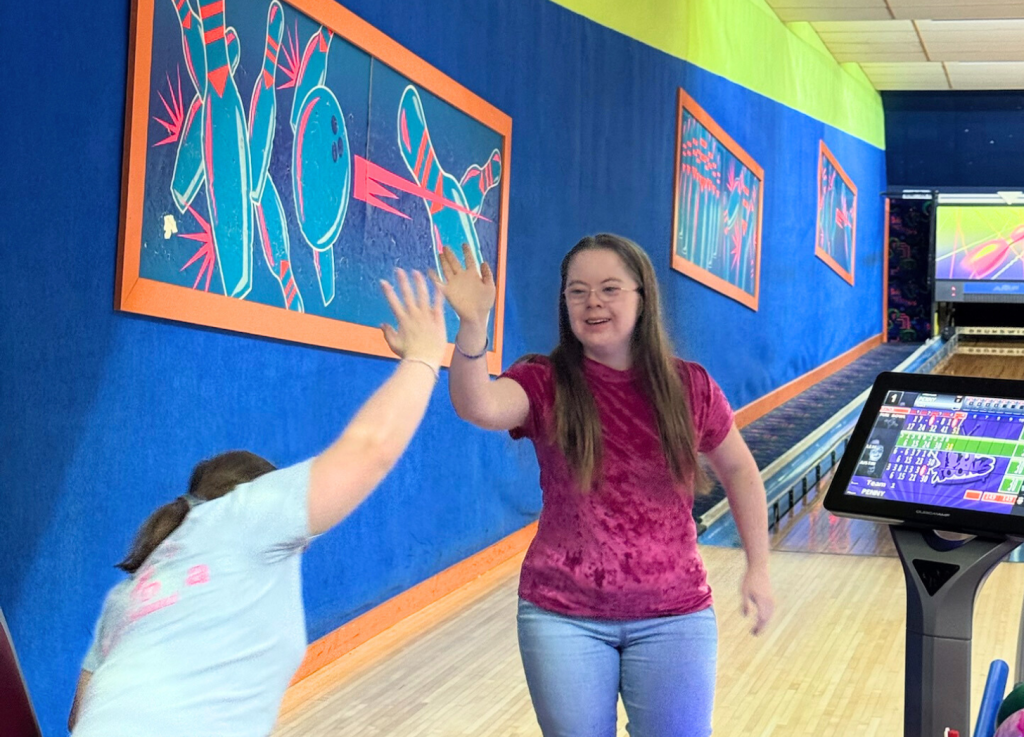 Penny giving her friend a high five at the bowling alley Penny giving her friend a high five at the bowling alley