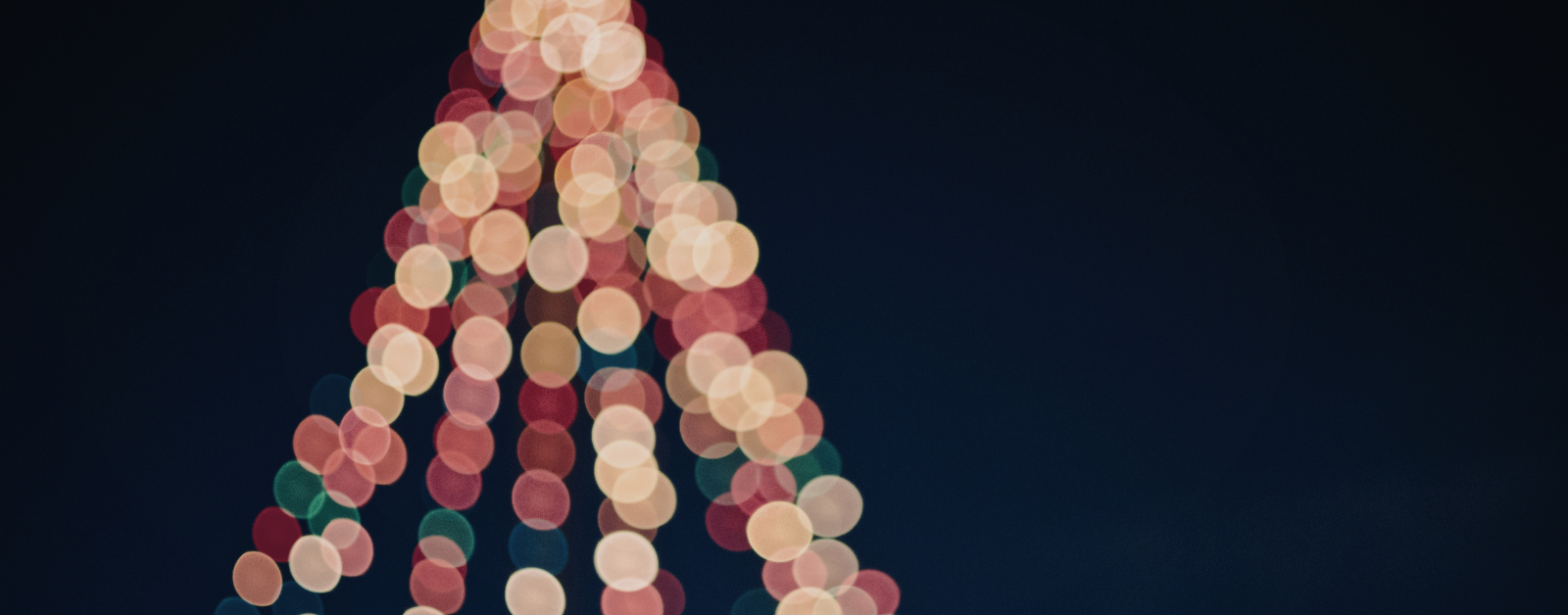 blurred Christmas lights on a Christmas tree against a dark background