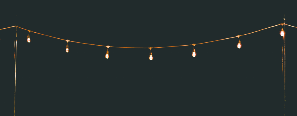 lights strung between poles on a dark night