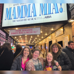 Amy Julia, Rachel, Penny, and Rachel's mom in front of the sign for Mamma Mia on Broadway