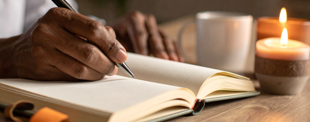 Hand Writing in Journal With Candlelight