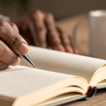 Hand Writing in Journal With Candlelight