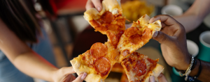 photo of hands pulling pizza slices