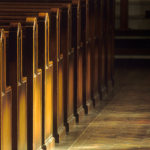 empty church pews in a dark church