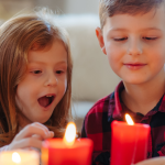 Young girl and boy indoors at home, looking at glowing candles
