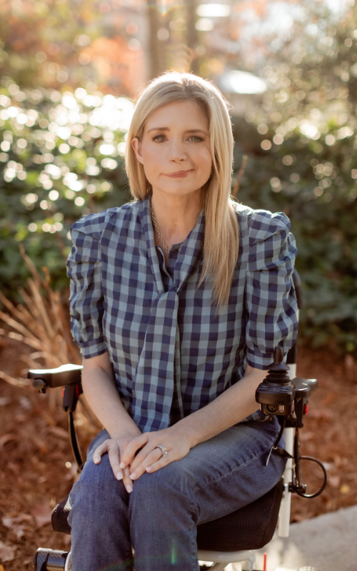Katherine Wolf poses for a portrait outside in a garden.