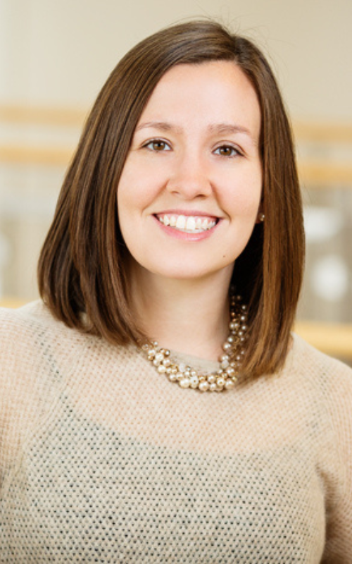 Meghan Burke poses for a portrait inside a library.