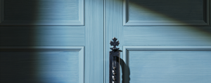 photo of a blue closed door with shadows across it