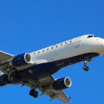 A delta airplane flying in the sky with a blue sky