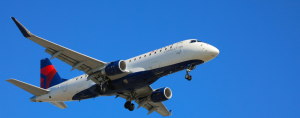 A delta airplane flying in the sky with a blue sky