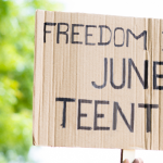concept of Juneteenth freedom day march showing by close up protesting hands sign board - concept of activism, justice and demonstration