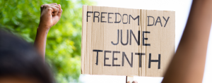 concept of Juneteenth freedom day march showing by close up protesting hands sign board - concept of activism, justice and demonstration