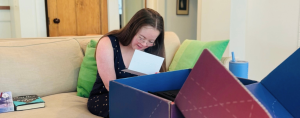 Penny, who has Down syndrome, reads a note that accompanied a surprise gift box from Delta Air Lines for her first solo flight.