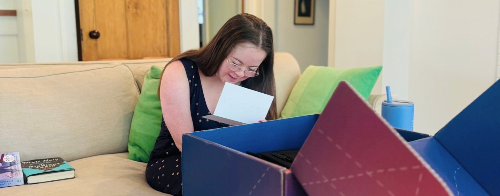 Penny, who has Down syndrome, reads a note that accompanied a surprise gift box from Delta Air Lines for her first solo flight.