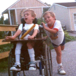 photo of Brian Trapp pushing his brother's wheelchair when they were kids