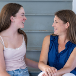 Marilee and I sit on steps, look at each other, and laugh together.
