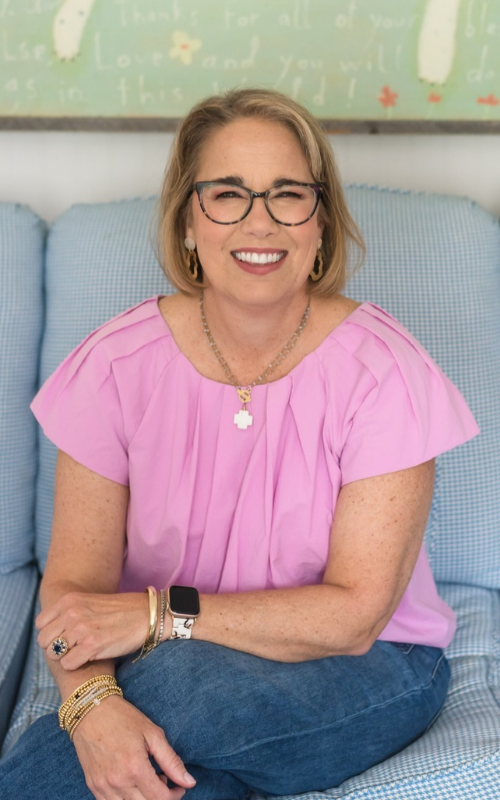 Sissy Goff sits a light blue couch in a bright room.