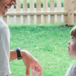 2009 photo of Peter and Penny sitting on a porch and look into each other's eyes. Green grass and a wooden fence are in the background