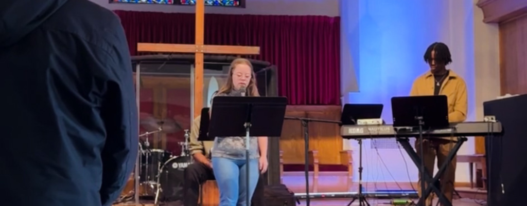 2024 photo of Penny leading our church in the Lord’s Prayer during the worship service