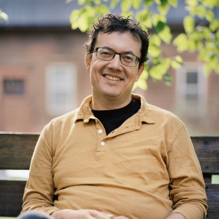 AJB-featured season 7(1560 × 628 px) – andrew leland (1) dark blue graphic with intertwined blue and yellow partial circles on the left and text that says: Reimagining the Good Life with Amy Julia Becker. In the middle of the graphic is a a photo Andrew Leland, who is a white man wearing a yellow shirt and sitting on a bench. On the far right is a photo of Amy Julia, a white woman who is wearing a blue shirt and smiling at the camera with her arms crossed in front of her