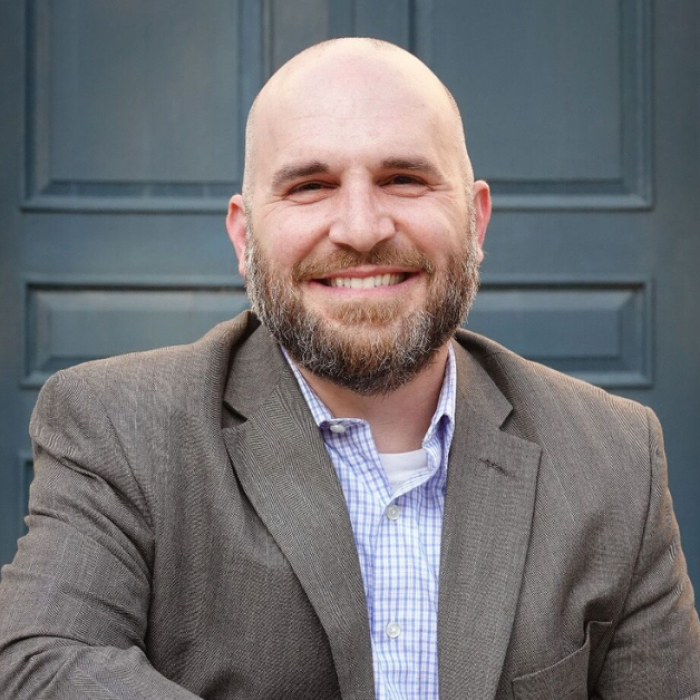 AJB-featured season 7(1560 × 628 px) – draper dark blue graphic with intertwined blue and yellow partial circles on the left and text that says: Reimagining the Good Life with Amy Julia Becker. In the middle of the graphic is a a photo Andrew Draper, a white man wearing a suit jacket sitting in front of a dark gray door. On the far right is a photo of Amy Julia, a white woman who is wearing a blue shirt and smiling at the camera with her arms crossed in front of her.