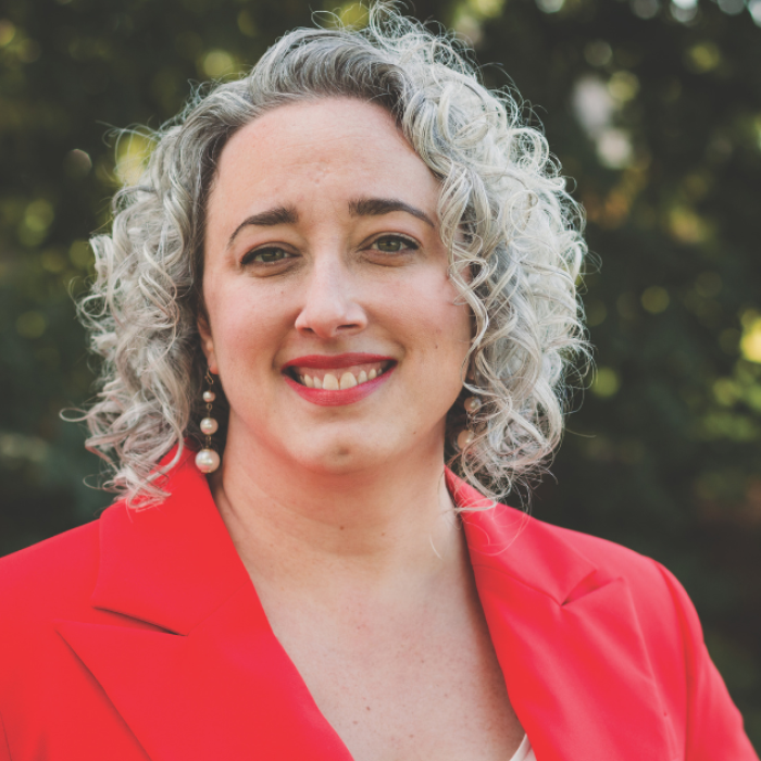 AJB-featured season 8 emily hunter mcgowin dark blue graphic with geometric shape overlays and the Reimagining the Good Life with Amy Julia Becker podcast logo in bottom right corner. In the middle of the graphic is a photo of Emily Hunter McGowin, Phd