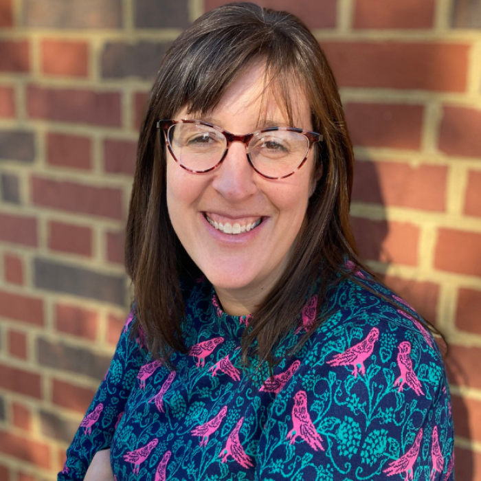 AJB-featured season 8 pepper stetler measure of intelligence dark blue graphic with geometric shape overlays and the Reimagining the Good Life with Amy Julia Becker podcast logo in bottom right corner. In the middle of the graphic is a photo of Pepper Stetler