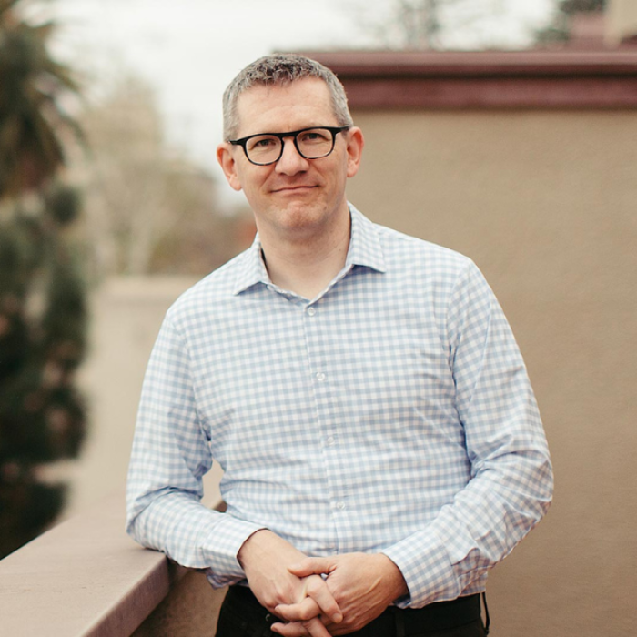 Crouch Season 8 dark blue graphic with geometric shape overlays and the Reimagining the Good Life with Amy Julia Becker podcast logo in bottom right corner. In the middle of the graphic is a photo of Andy Crouch