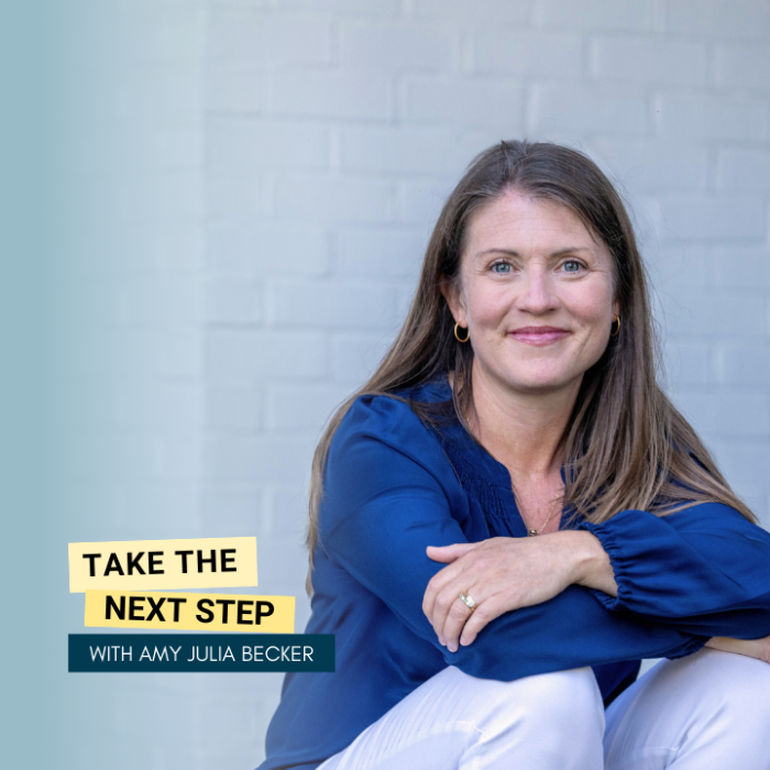 Amy Julia sits on a porch resting her arms on her knees